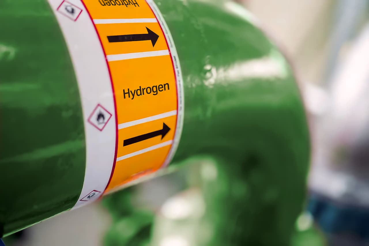 Etiqueta en tubería industrial señalando el flujo de hidrogeno